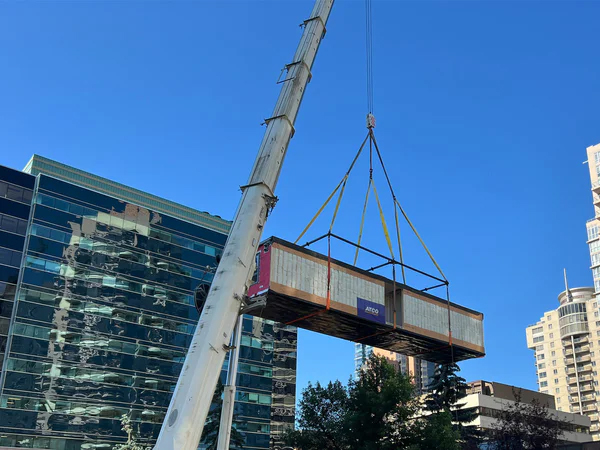 Photo of a crane lifting part of a modular building