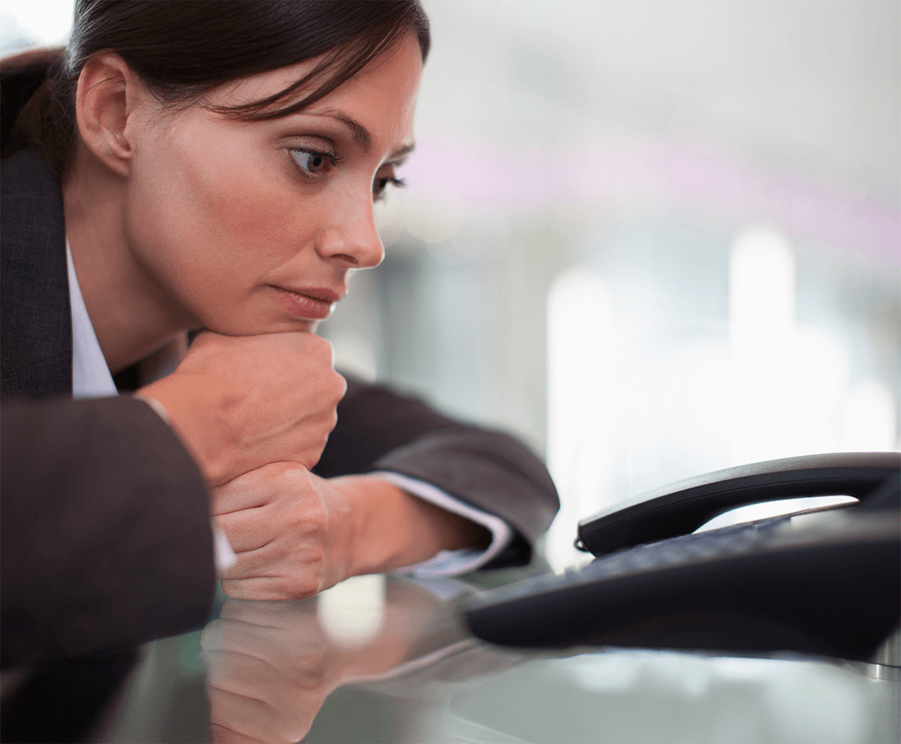 A woman gazes intently at her phone, absorbed in the screen's content.