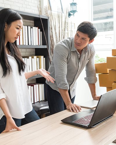 Shop owners checking product stock on computer
