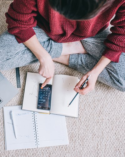 Women using phone calculator and taking notes