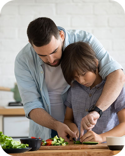 Father and son cutting up vegetables