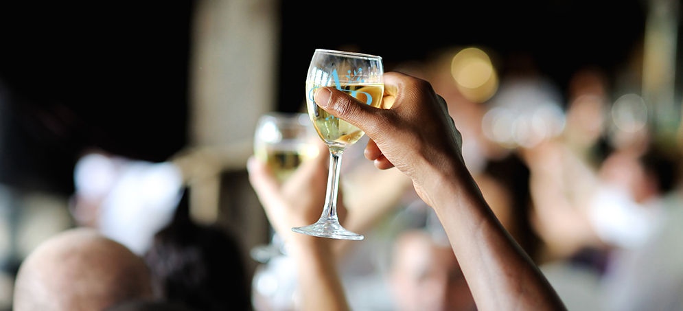 Raising a monogramed wine glass at a wedding