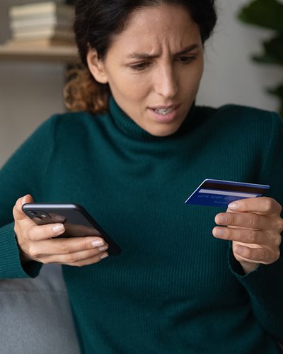 Women ordering on a phone with credit card in other hand