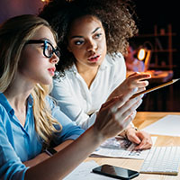 Two women working together to solve a problem