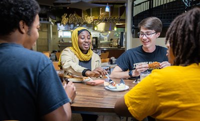 Students sharing food in restaurant